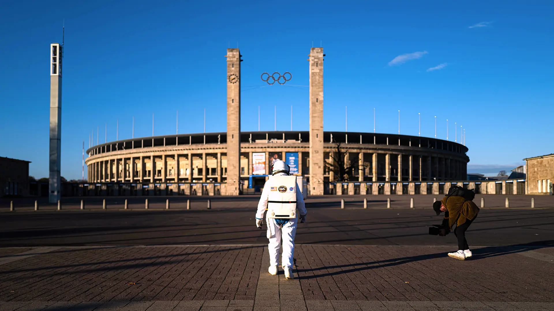 Ein Bild zeigt einen Astronauten vor dem Olympia Stadion Berlin.