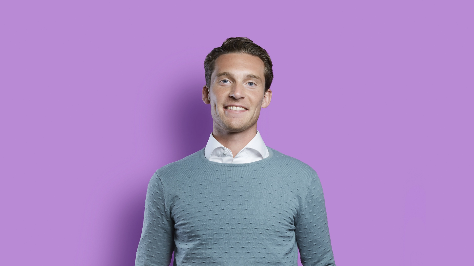 Ein Bild zeigt einen Mann auf Lila Hintergrund bei einem Fotoshooting von Freshfields Rechtsanwälte zur Kampagne 